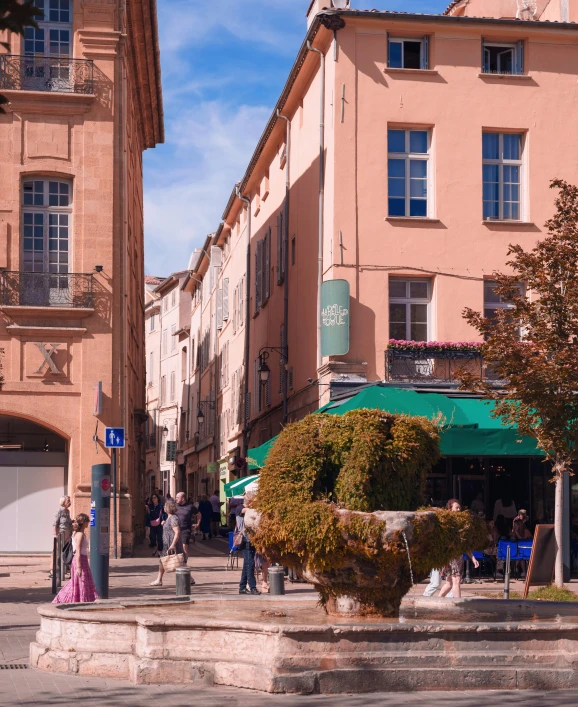 people walking down an old city street on a sunny day