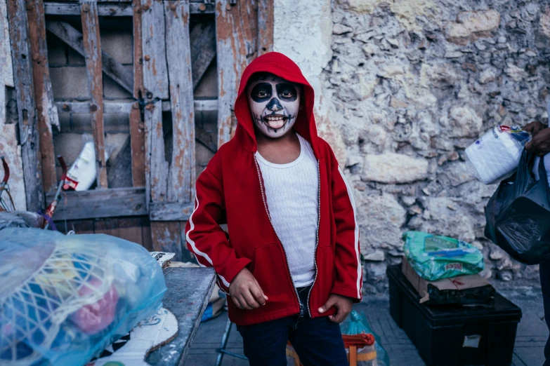 a person with halloween make up wearing a red jacket