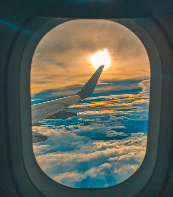 a window looking down into the clouds and sun