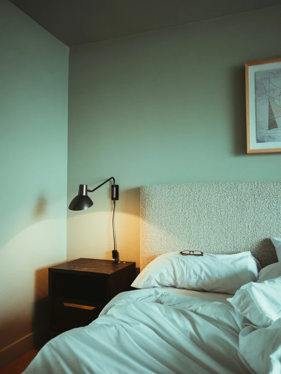 a small bed with pillows and a lamp by it