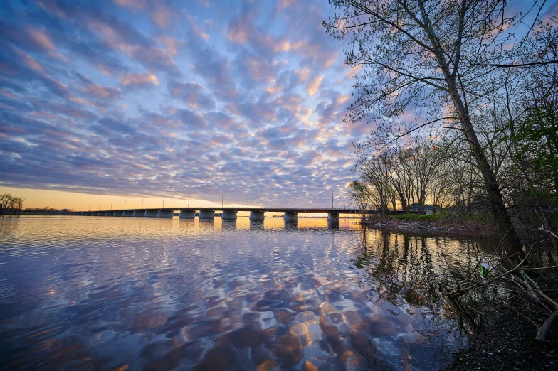 blue cloudy sky reflected in water with bridge