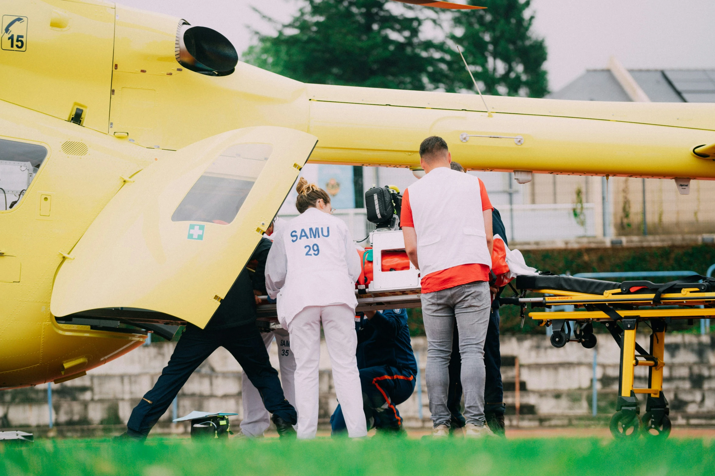 some people loading soing onto a helicopter in the grass