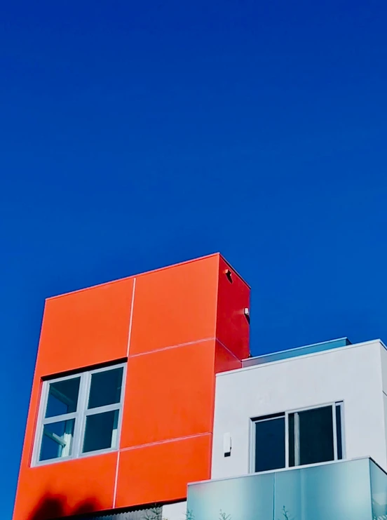 a large red and white building is shown on a sunny day