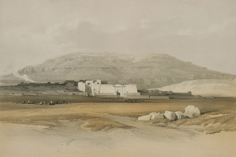 an old building sitting in the middle of a field with mountains