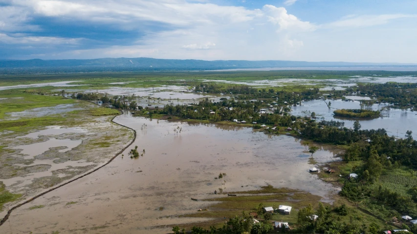 this aerial view shows the swampy marshy ground, muddy water, and houses