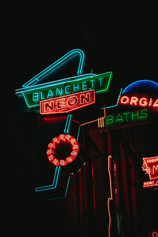 many neon signs on the outside of a building