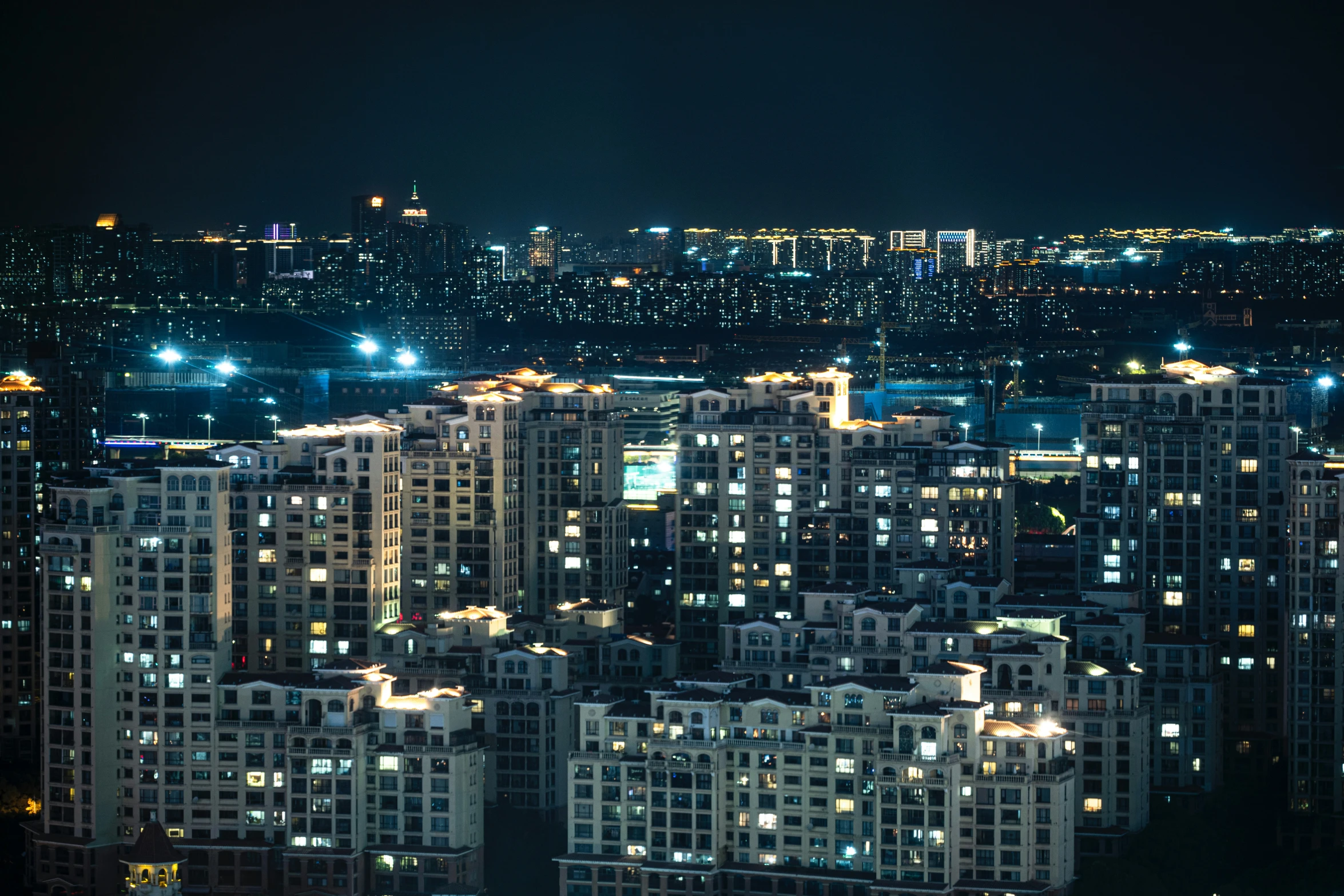 the view from a hill at night shows several buildings in a city