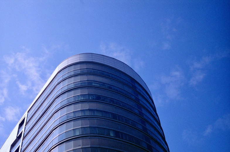 blue glassy building with a few clouds in background