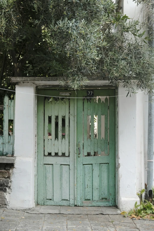 two green doors are open outside of an old building