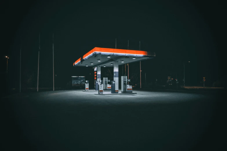 a gas station sits empty at night, with no one around