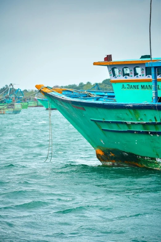 the large fishing boat is parked near a sandy shore