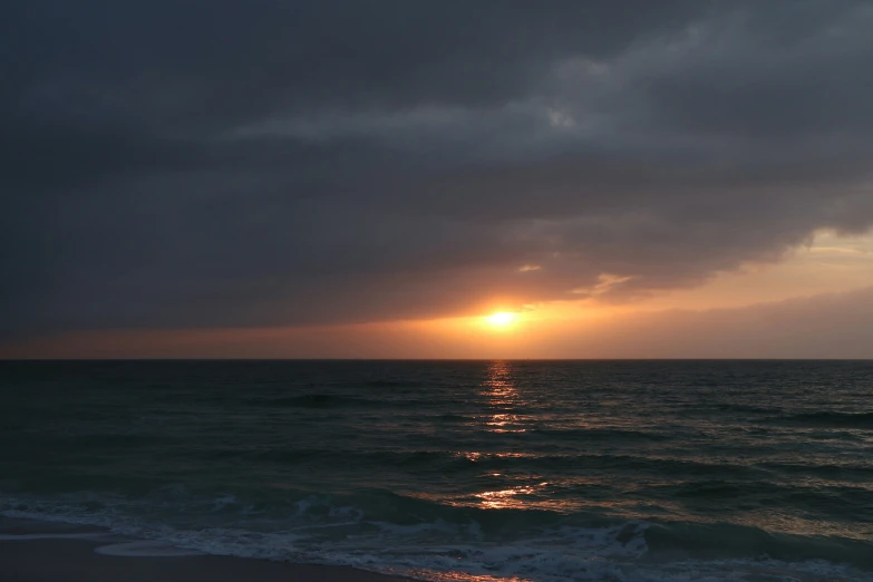 the sun sets as the horizon reflects in the water