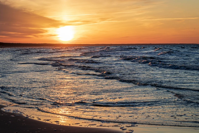 the sun is setting over the ocean water