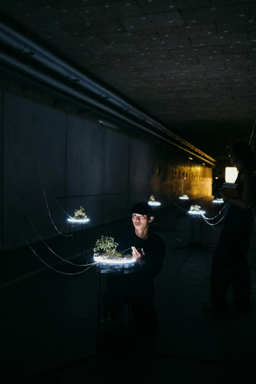 two people standing in a dark tunnel by a small lit table