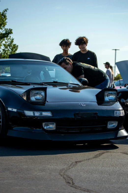 two s look at a car parked by some other cars