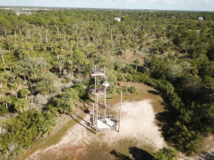 a telephone tower surrounded by trees and dirt