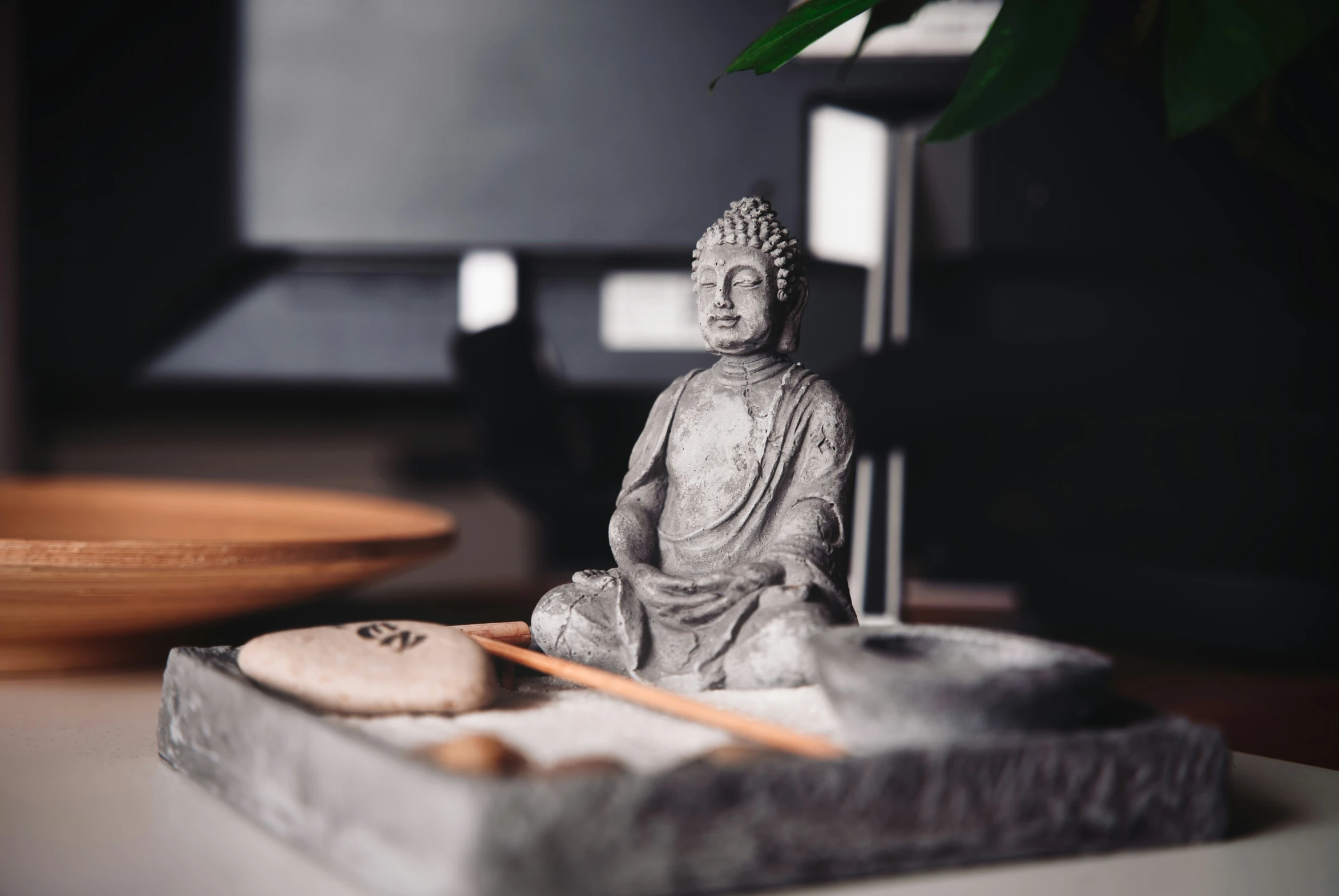 a statue sitting on a table with a bowl and chopstick