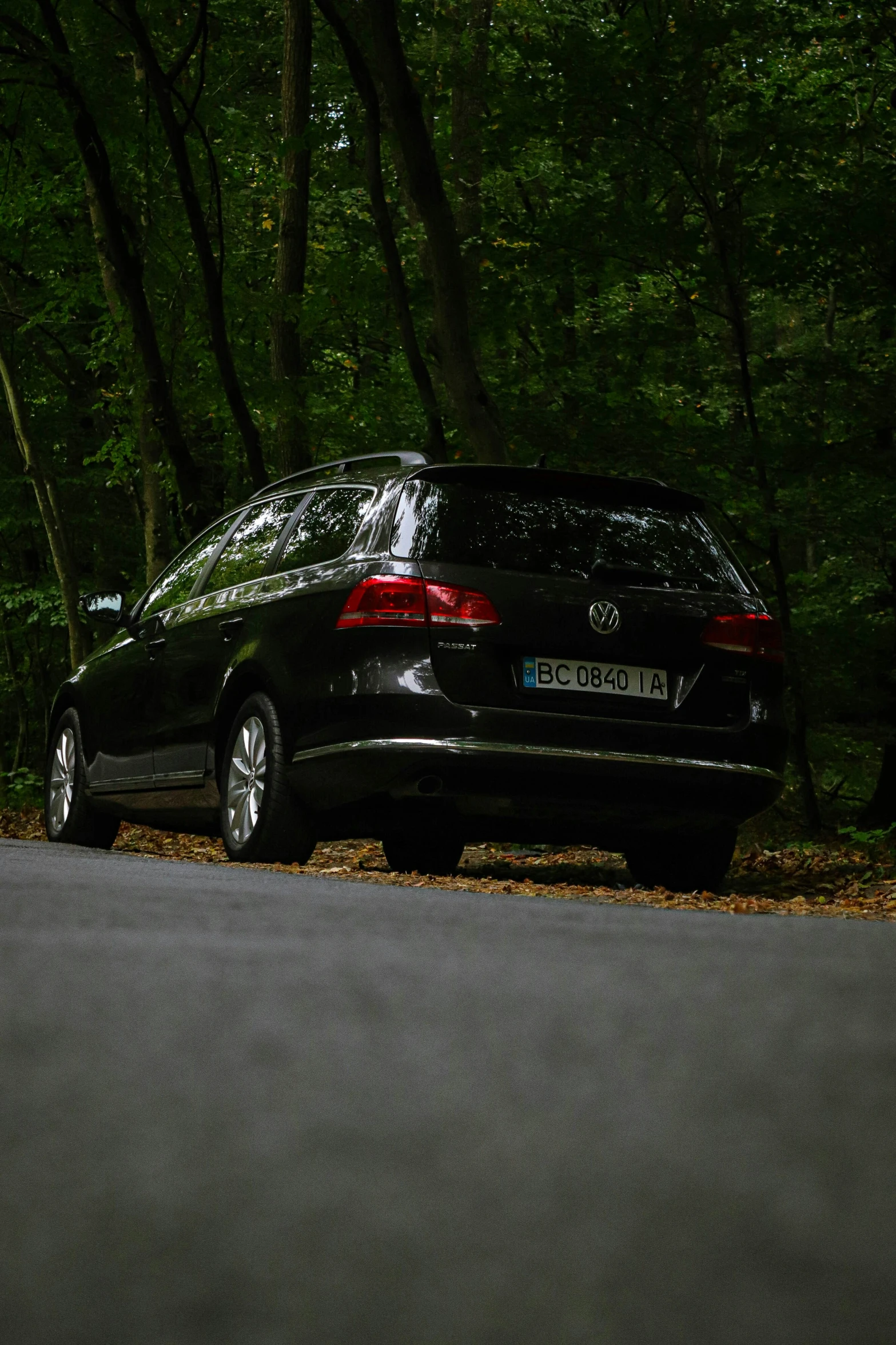 a car parked on a street in a wooded area