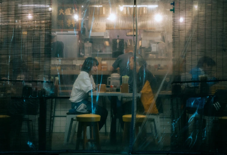 a restaurant with three people and several yellow stools