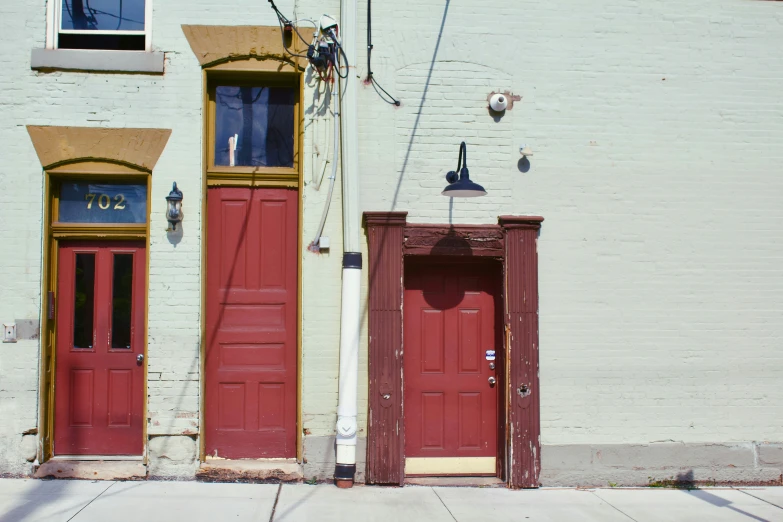 two large red doors sit outside of two buildings