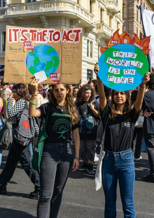 two women hold signs on the street and hold up placards