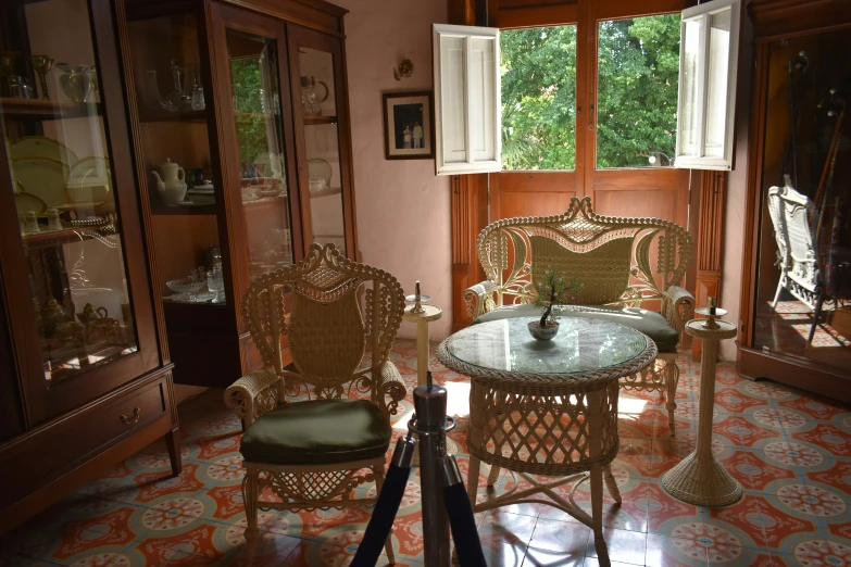 an empty room has wicker furniture, and there are many windows on the wall