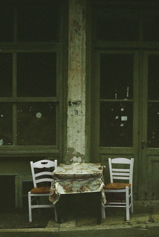 three chairs sitting in front of a table covered in a cloth