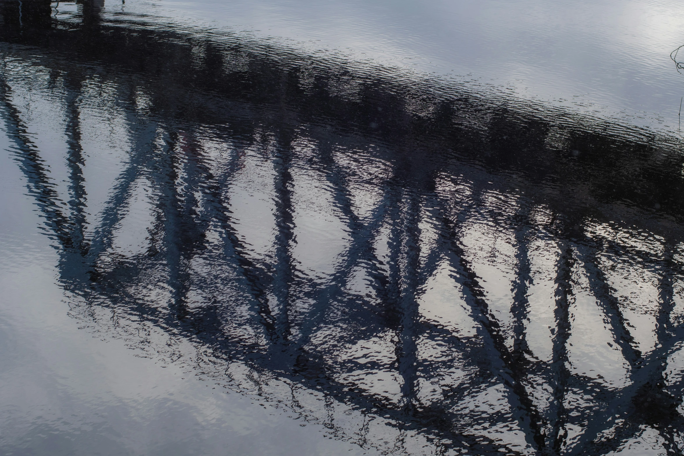 a reflection of a large bridge in a body of water