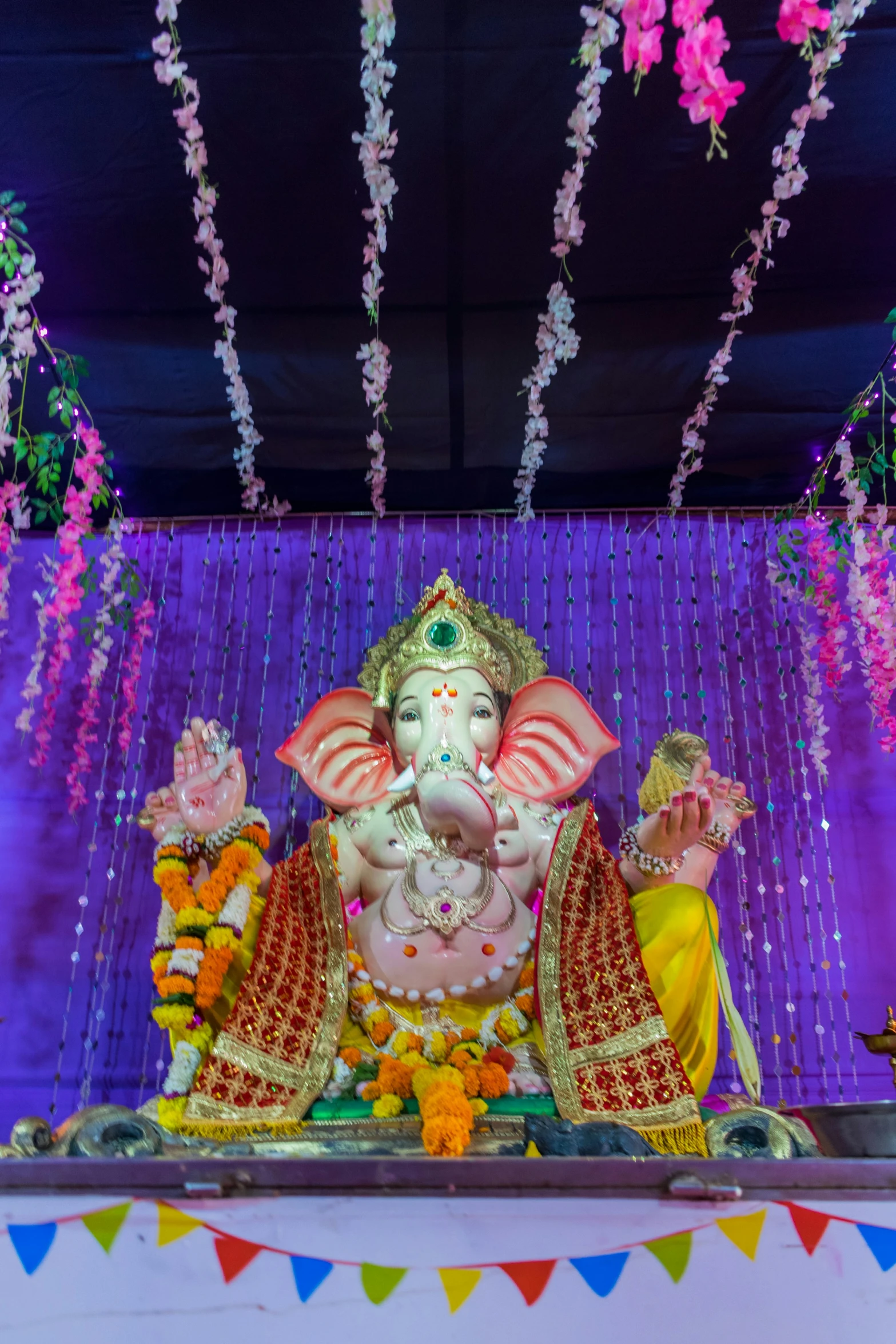 a large elephant with large tusks and sitting under lights