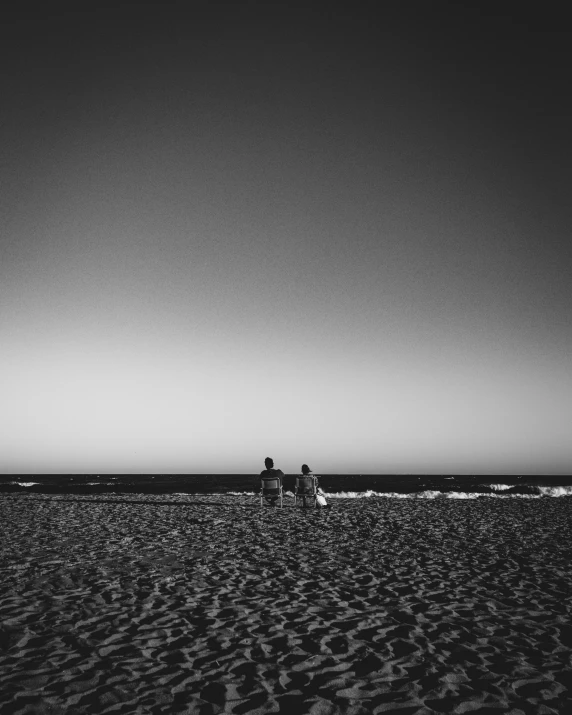 people are on the beach at sunset