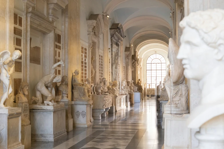 a statue of the greek ruler standing on a marble corridor with sculptures