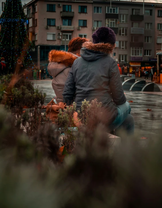 two people sit next to each other in the rain