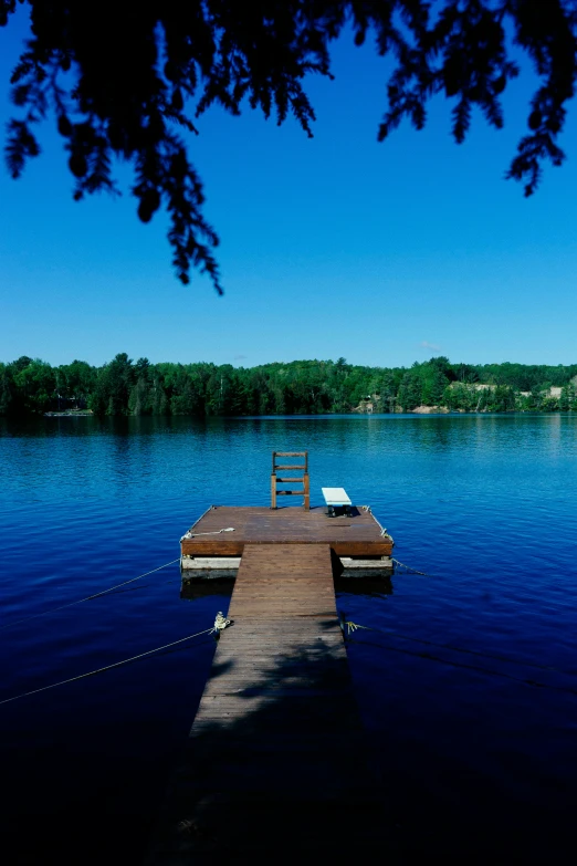 a boat dock is sitting out in the middle of a lake