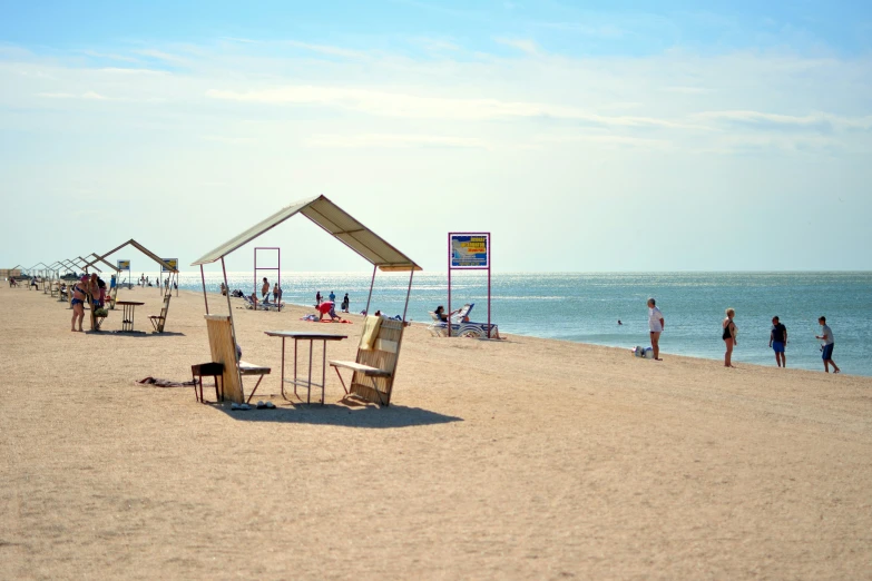 people on the beach near umbrellas and a table