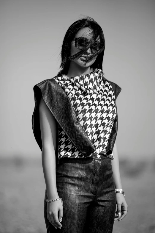 woman standing on sand with sunglasses on her head