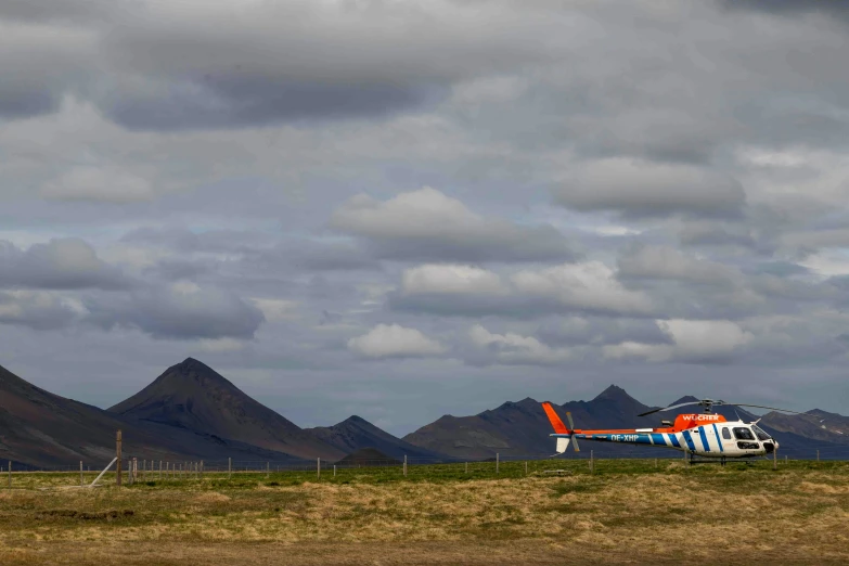 a single propellor helicopter on a mountain terrain