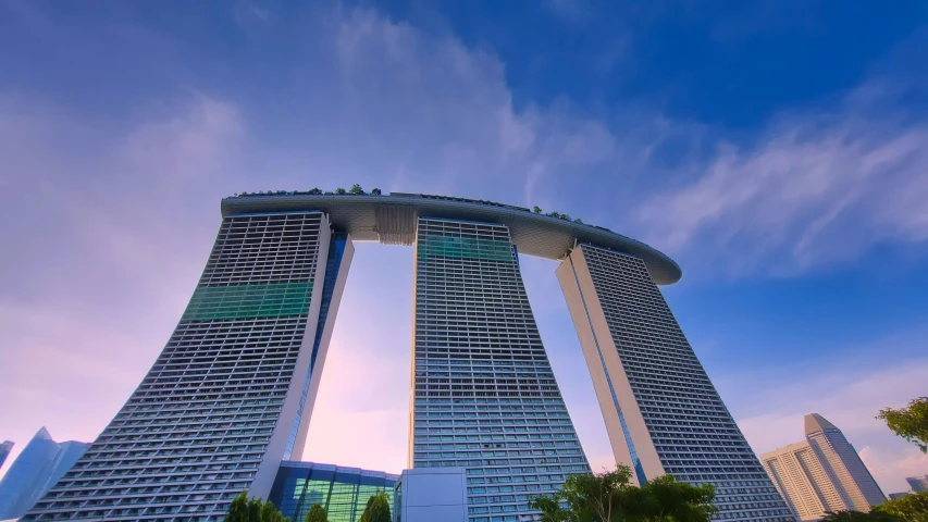 two tall buildings stand in the foreground of an otherwise cloudy sky