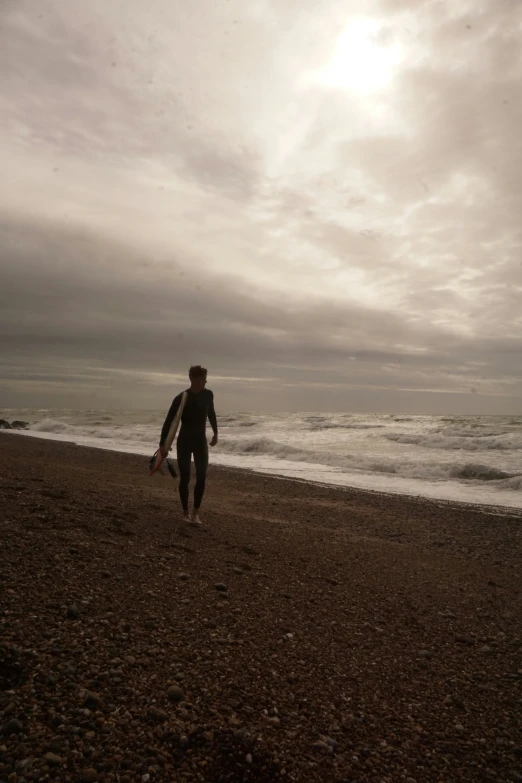 a man with a surfboard is walking on the beach