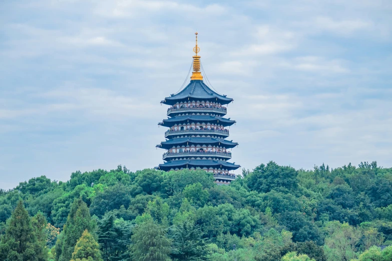 a very tall tower surrounded by trees in the middle of the day