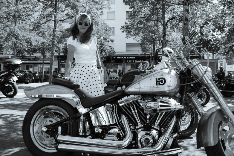 a beautiful woman standing on top of a motorcycle