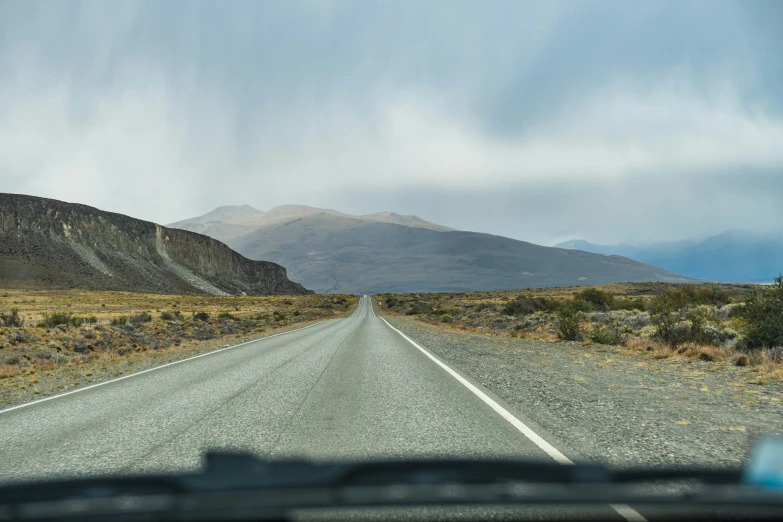 the dashboard of a vehicle driving on a long open highway