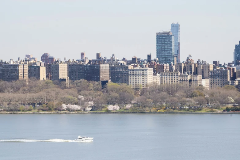 some tall buildings over the water and a white boat