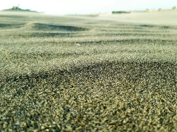 a sandy beach is pictured with some tiny rocks