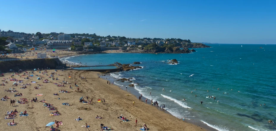 a beach that has people swimming in the water