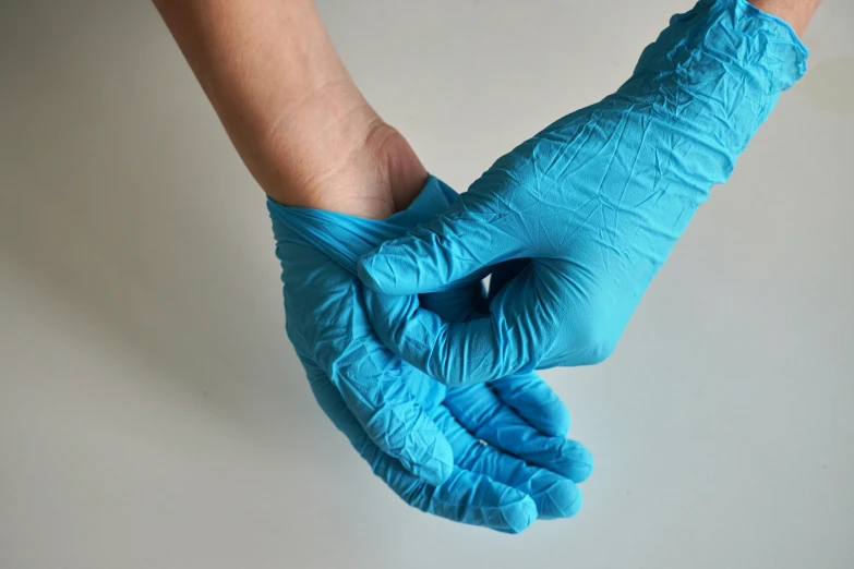 hands in blue gloves on a white background