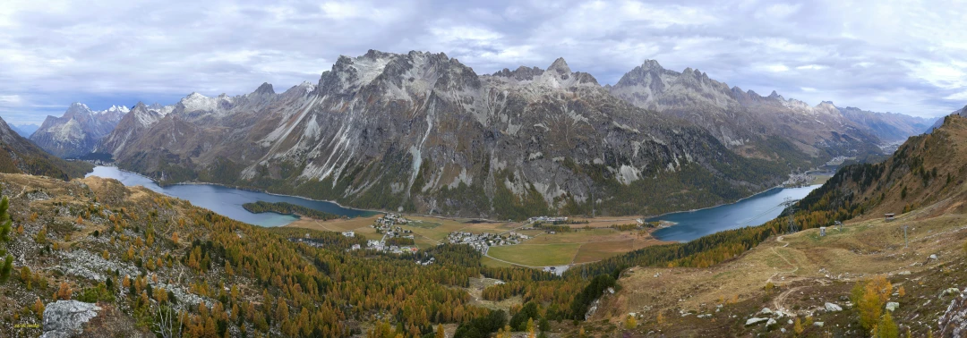 an overlook view from atop a mountain with snow covered peaks