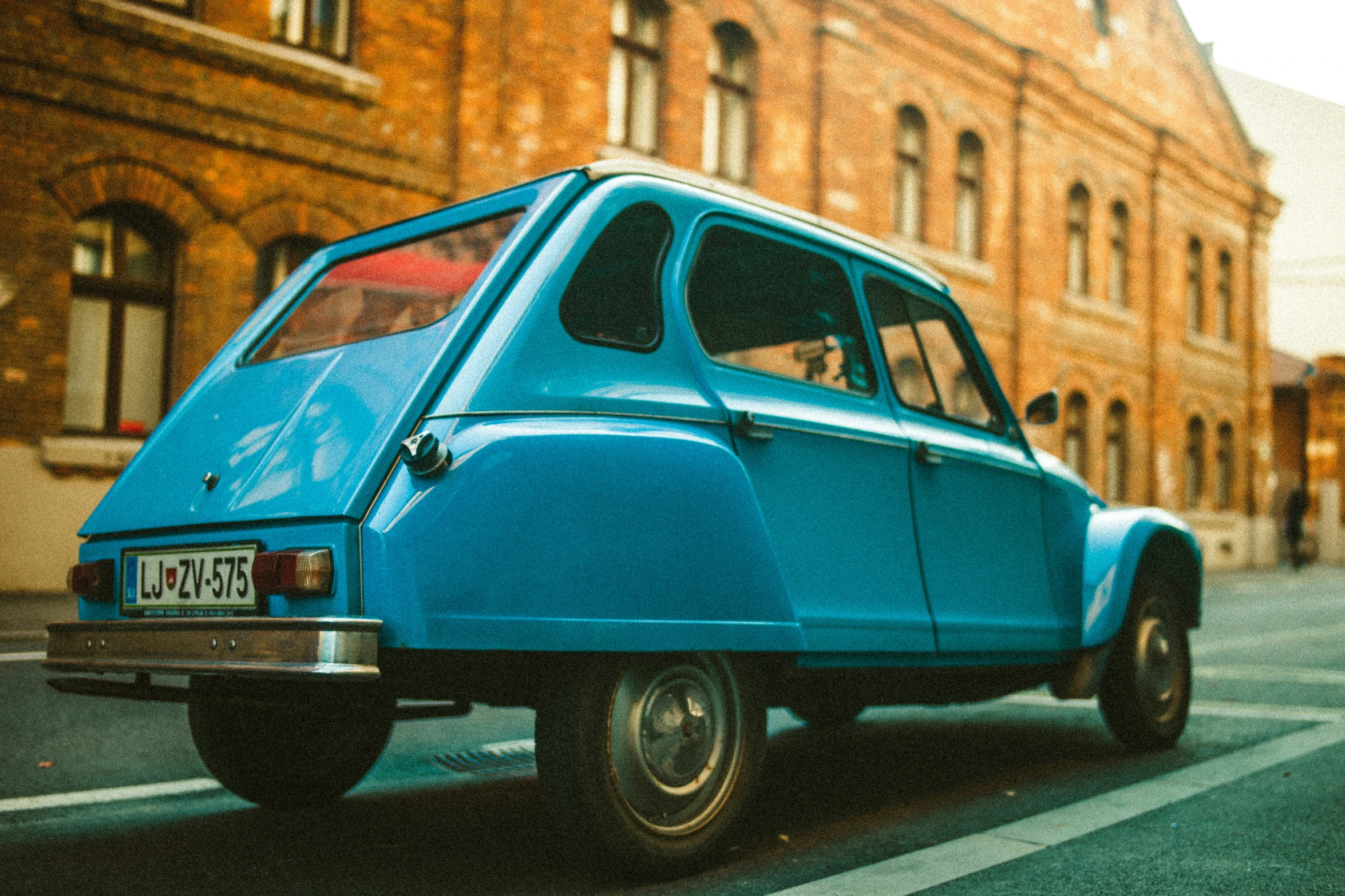 this old blue car is parked on the street