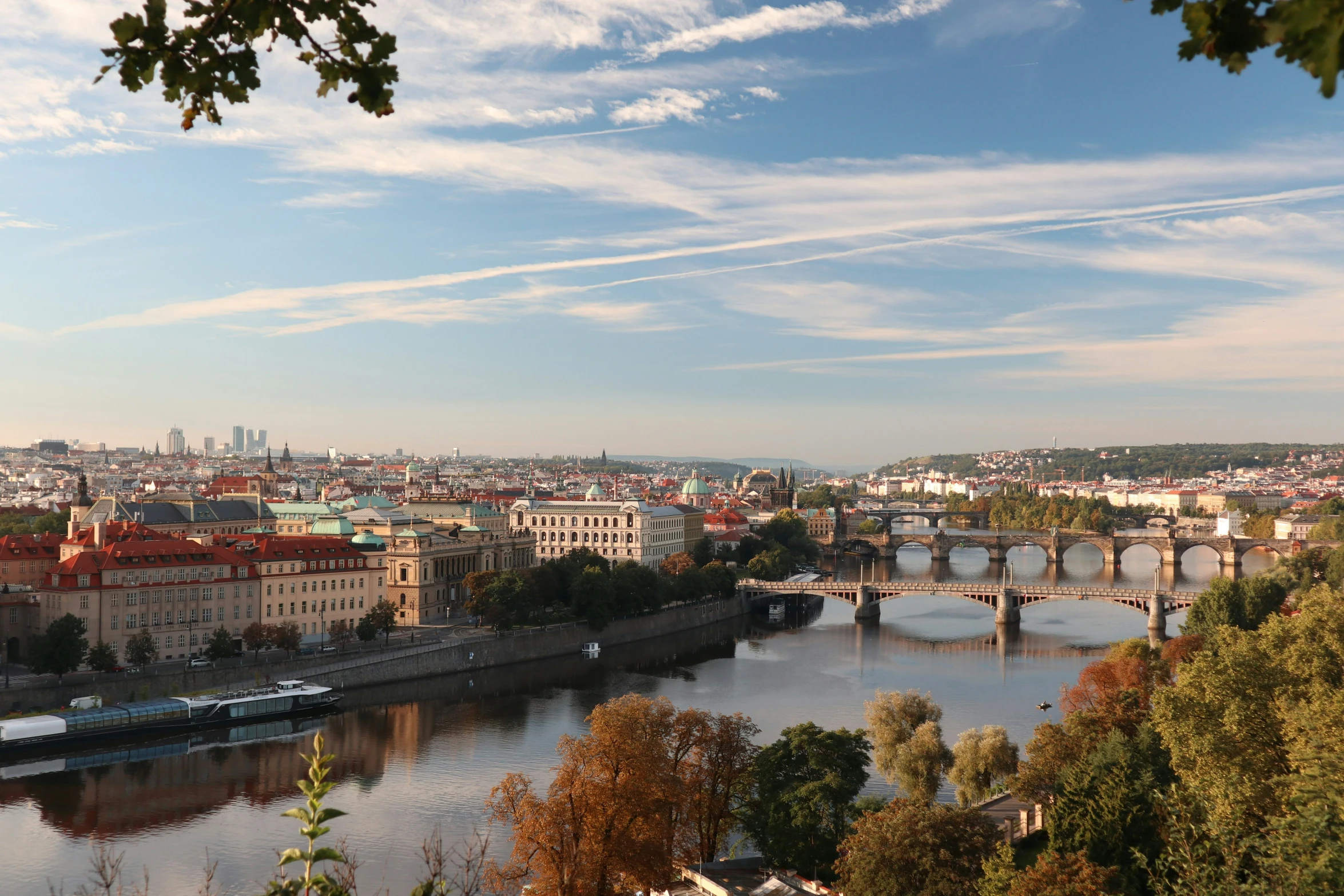 a river and bridge with old buildings in the background