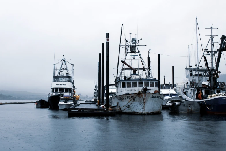 a dock with multiple boats on a wet day