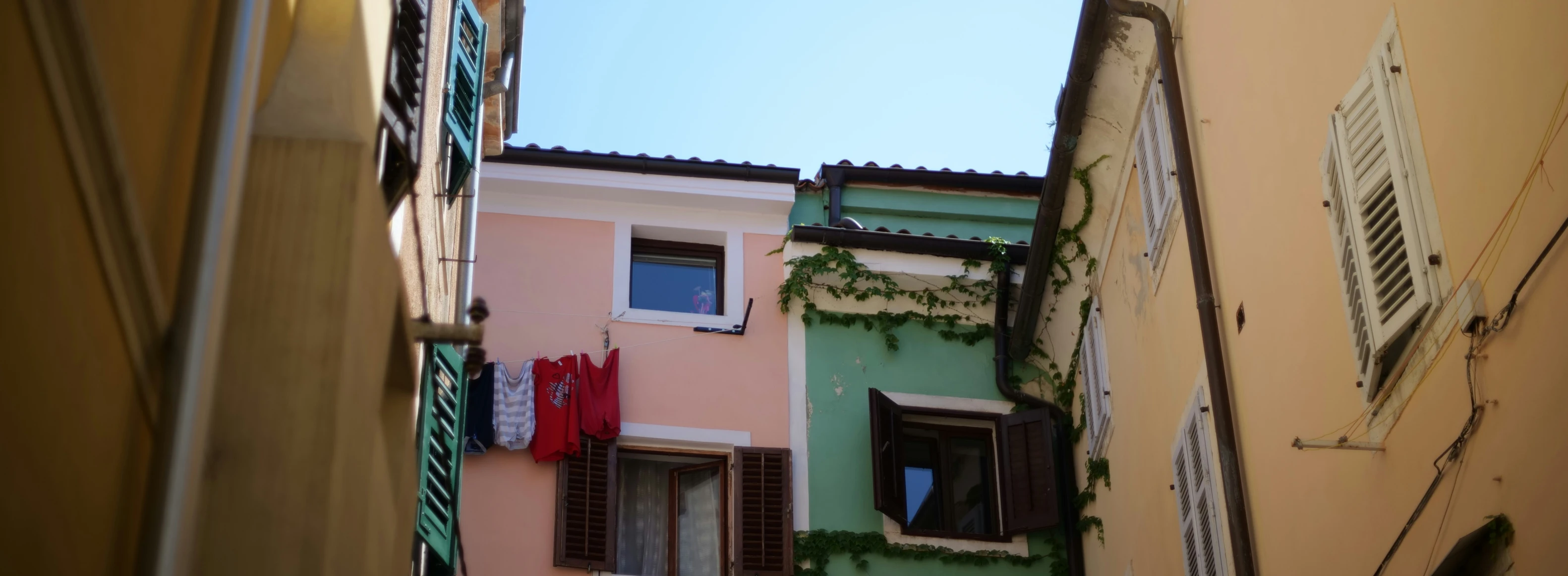 the building is colorfully painted with windows and shutters